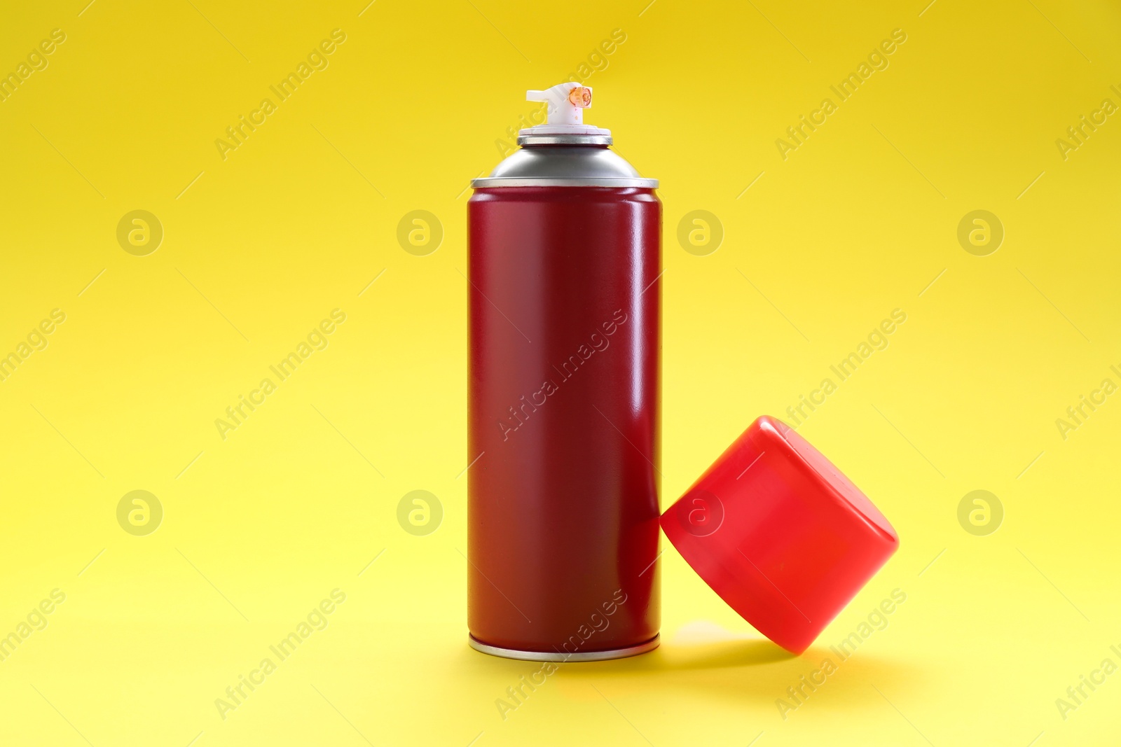 Photo of Red spray paint can on yellow background