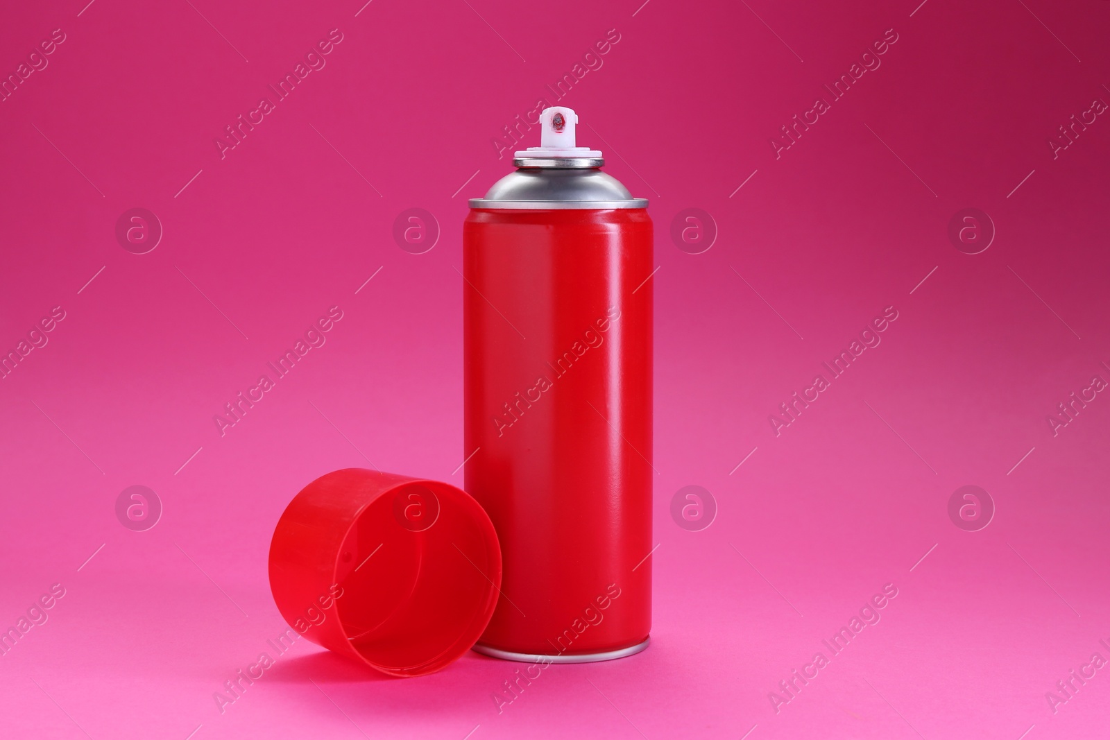 Photo of Red spray paint can on pink background