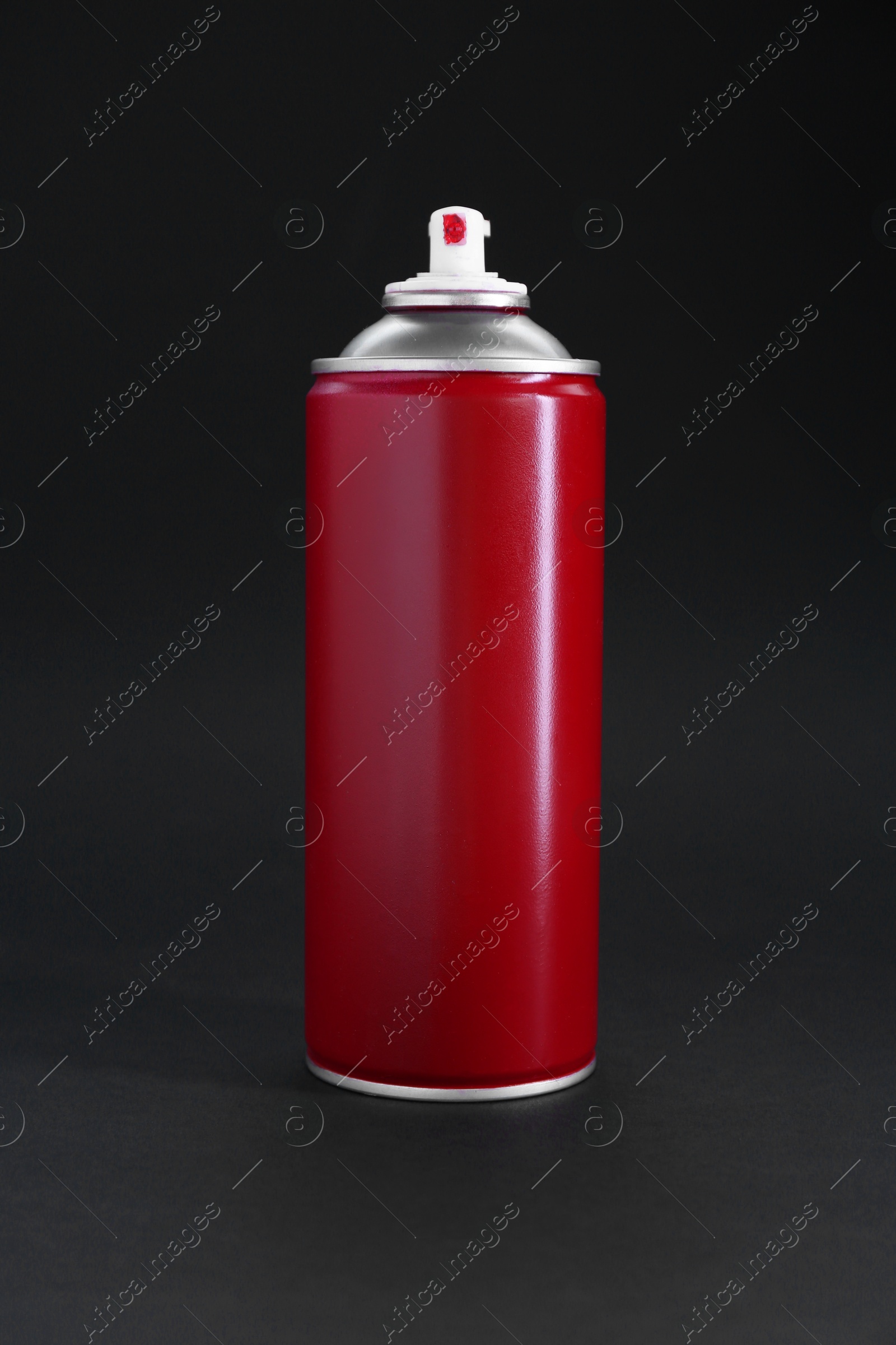 Photo of Red spray paint can on dark gray background