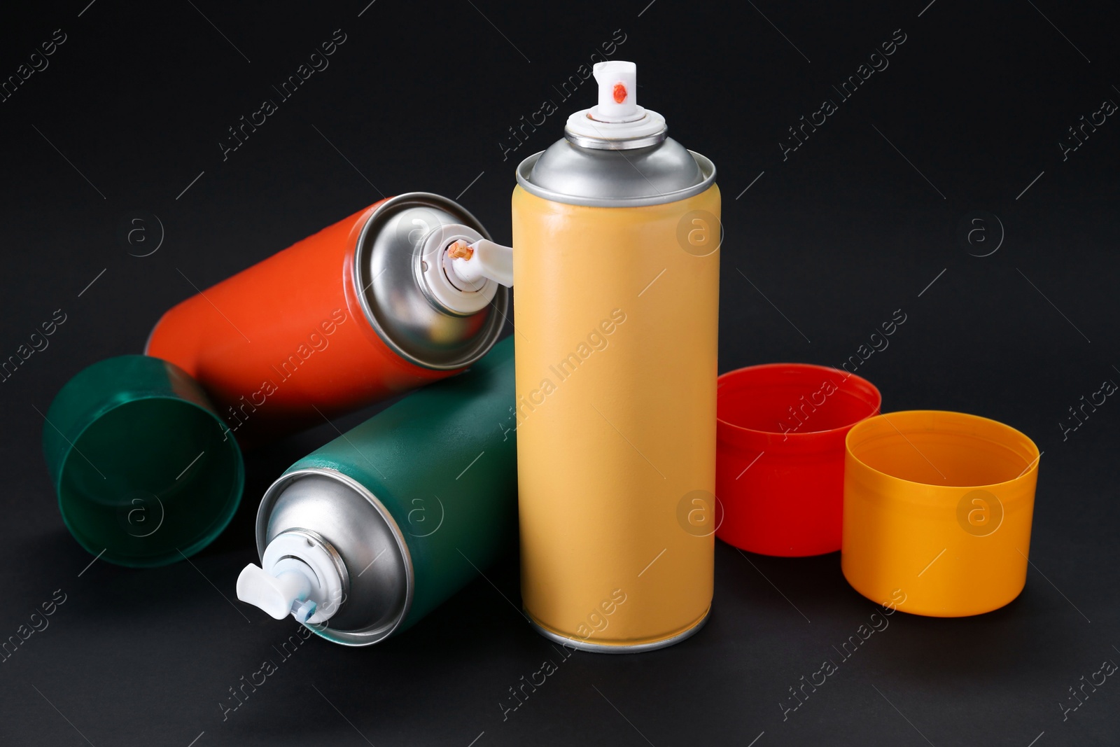 Photo of Many spray paint cans on dark gray background