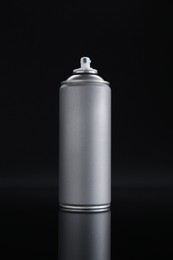 Photo of Gray spray paint can on black background