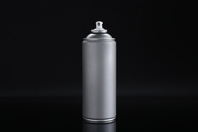 Gray spray paint can on black background