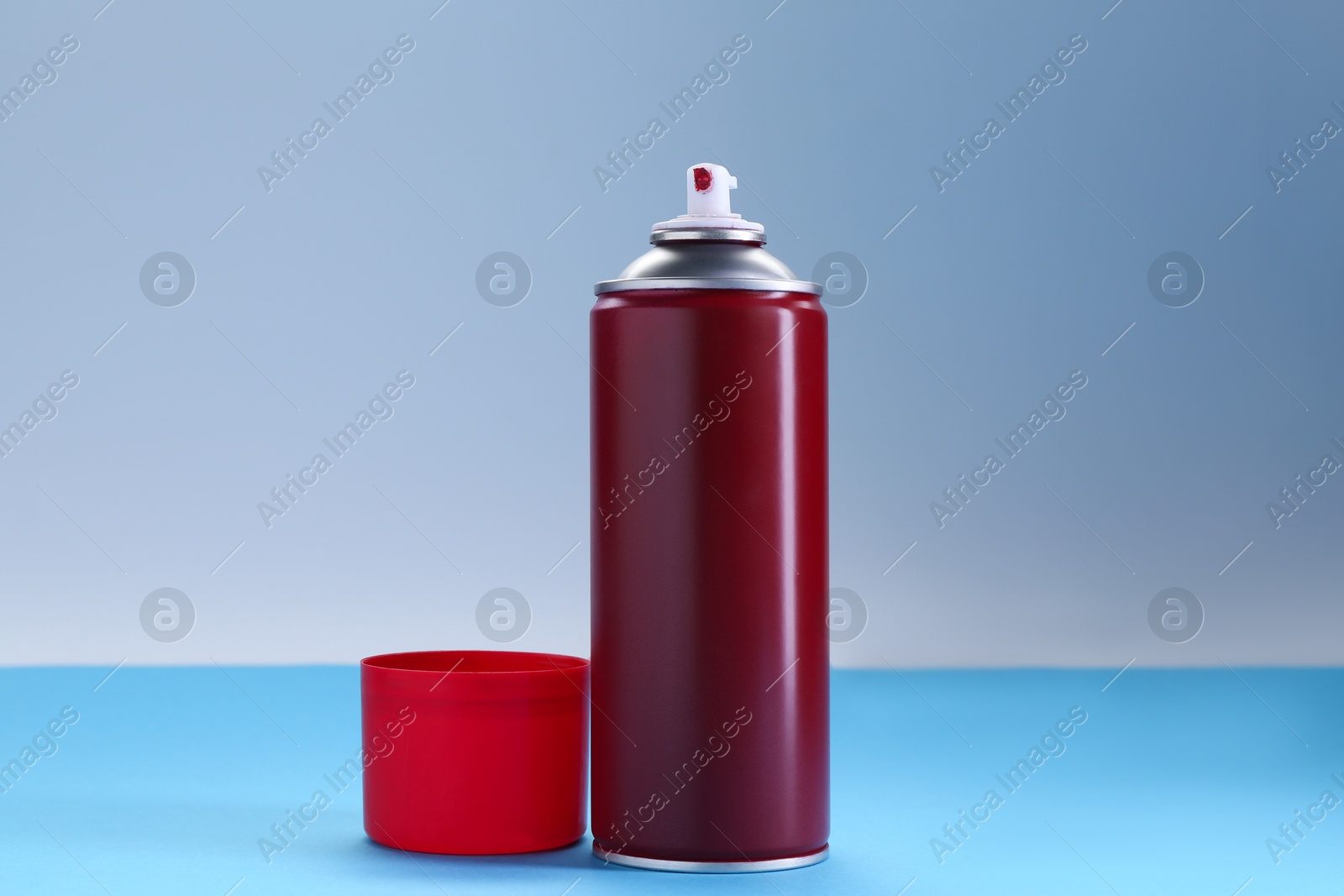 Photo of Red spray paint can on color background