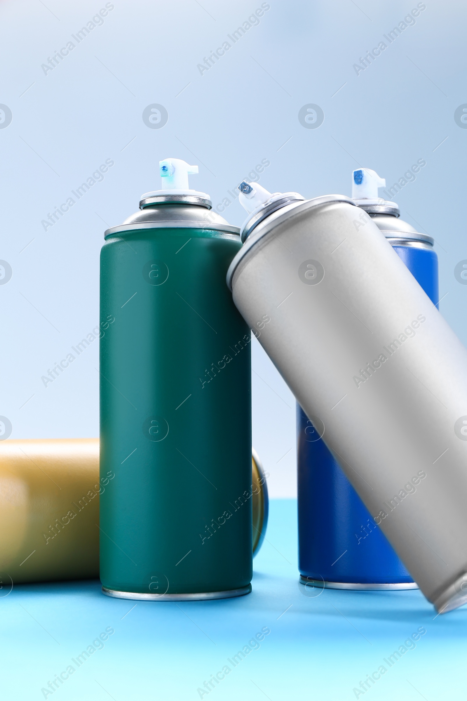 Photo of Many spray paint cans on color background