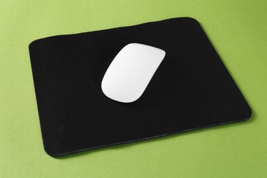 Photo of Wireless mouse and mousepad on green background