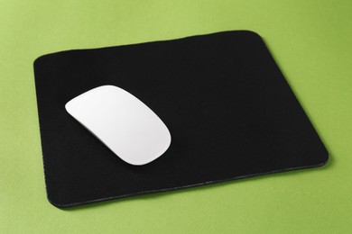 Photo of Wireless mouse and mousepad on green background