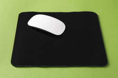 Photo of Wireless mouse and mousepad on green background