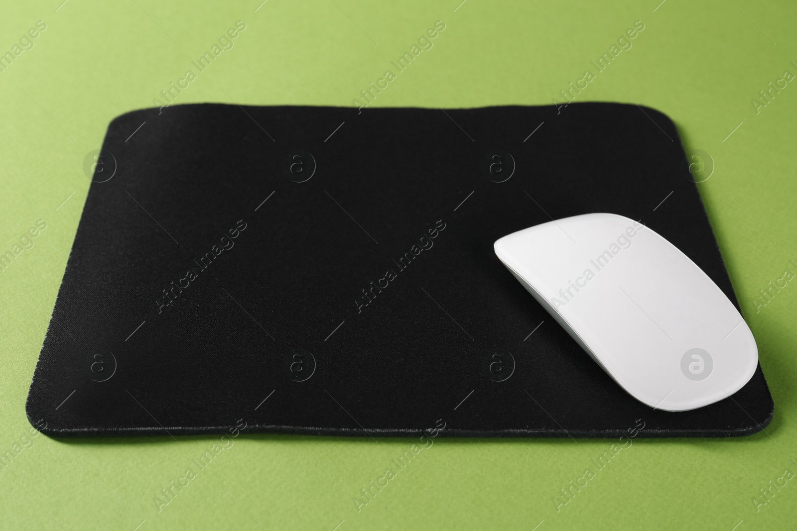 Photo of Wireless mouse and mousepad on green background