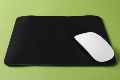 Wireless mouse and mousepad on green background