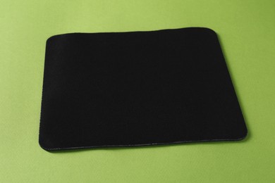 One black mouse pad on green background