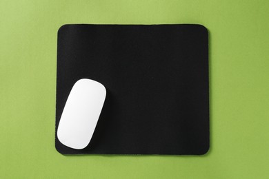 Photo of Wireless mouse and mousepad on green background, top view