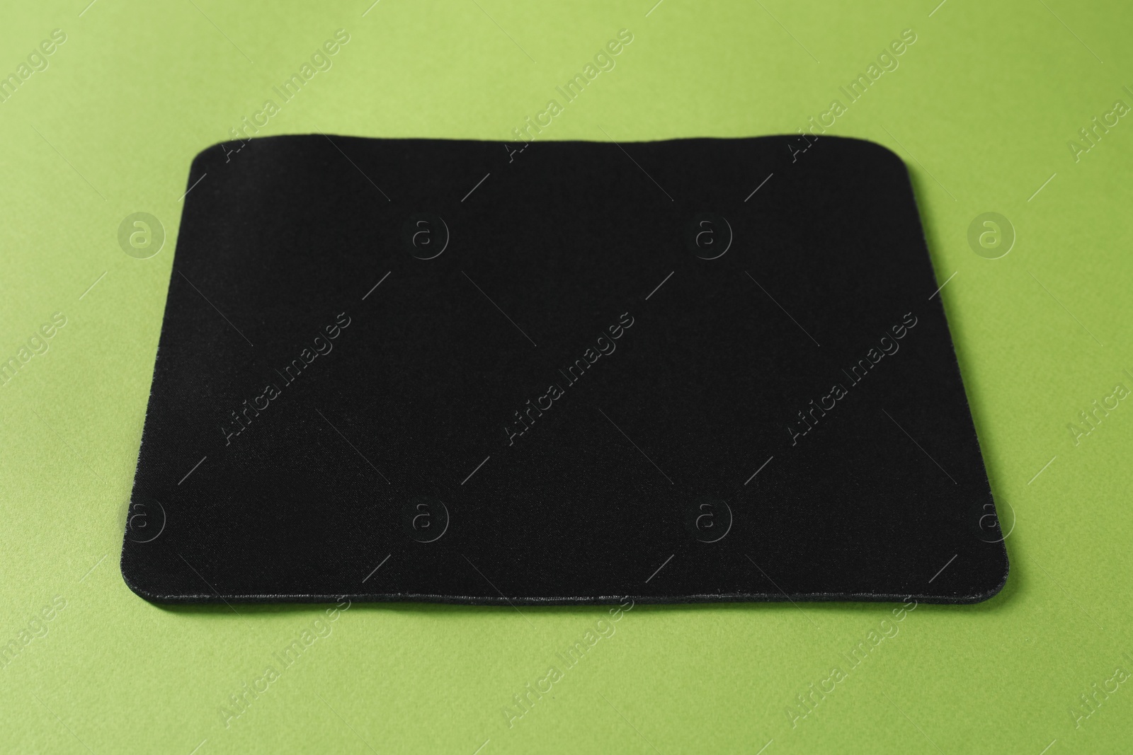 Photo of One black mouse pad on green background