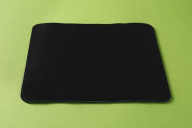 One black mouse pad on green background