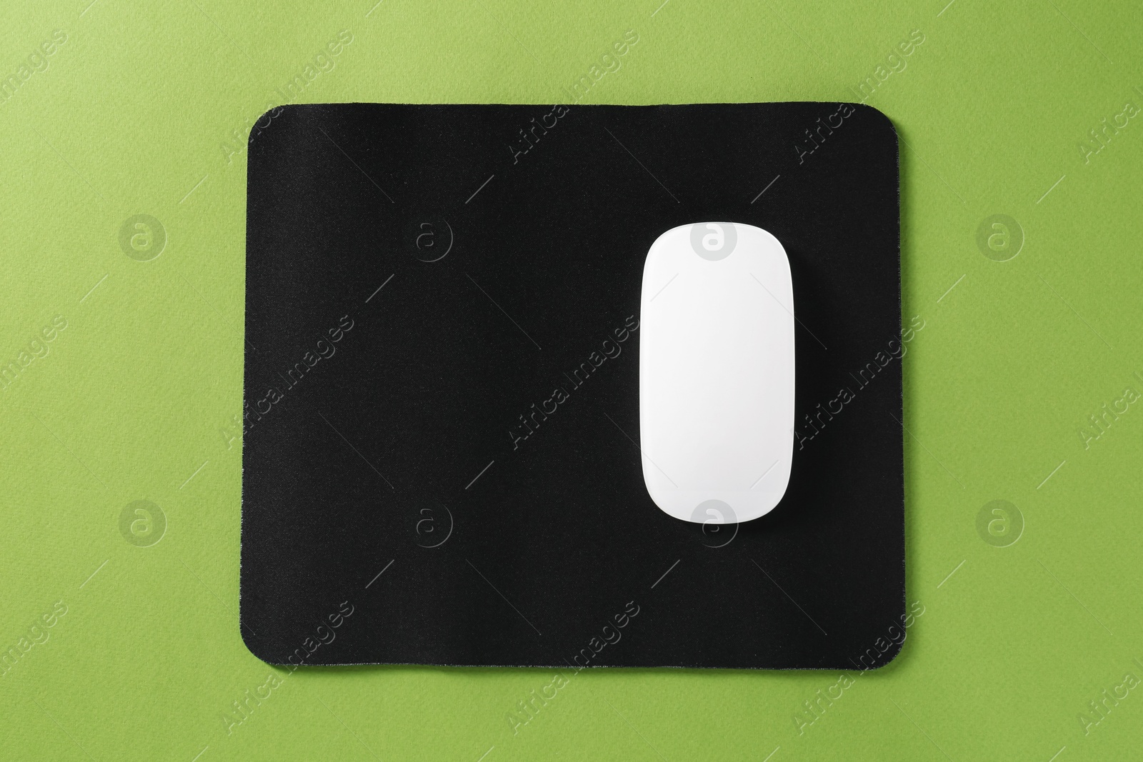 Photo of Wireless mouse and mousepad on green background, top view