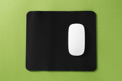 Wireless mouse and mousepad on green background, top view