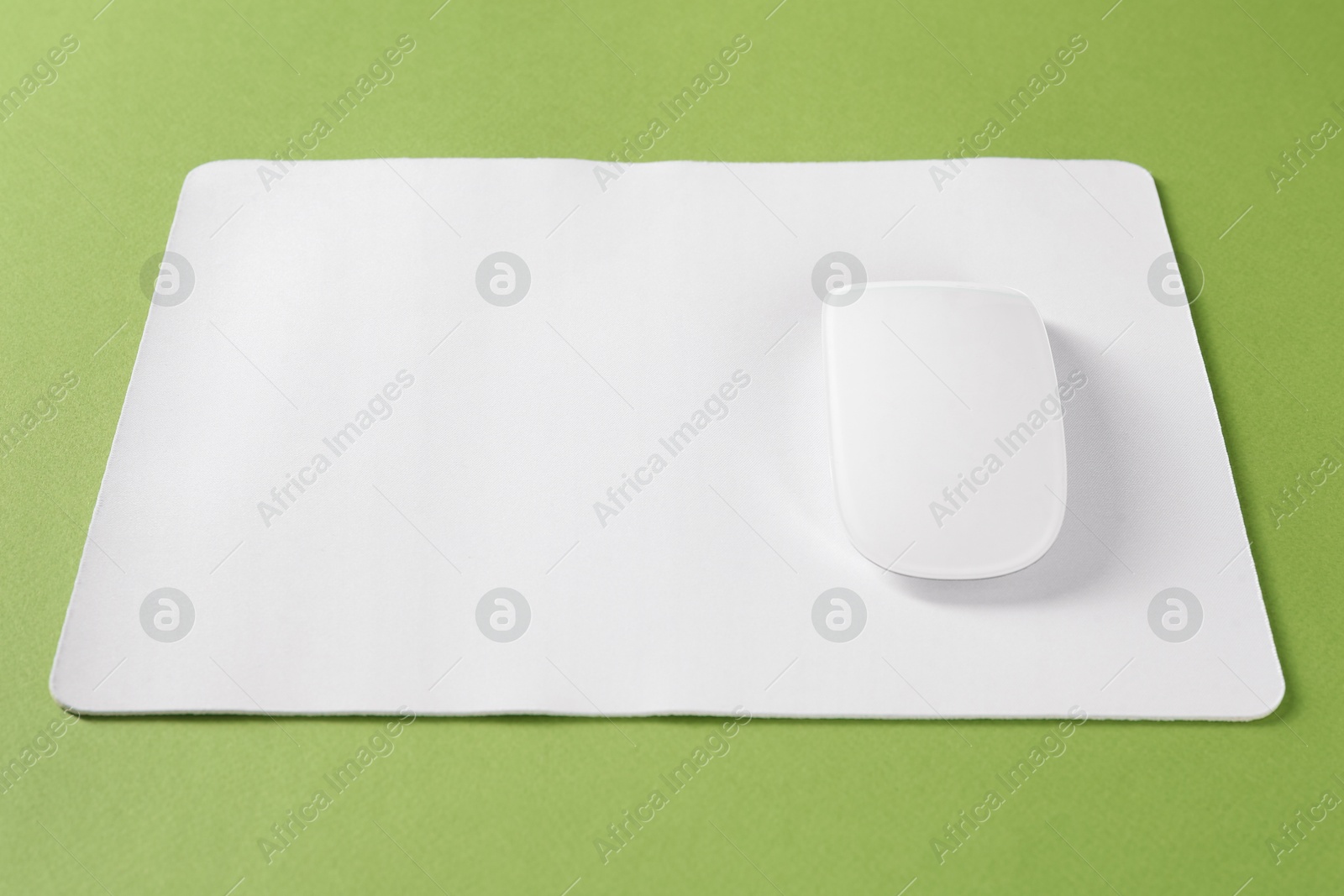 Photo of Wireless mouse and mousepad on green background