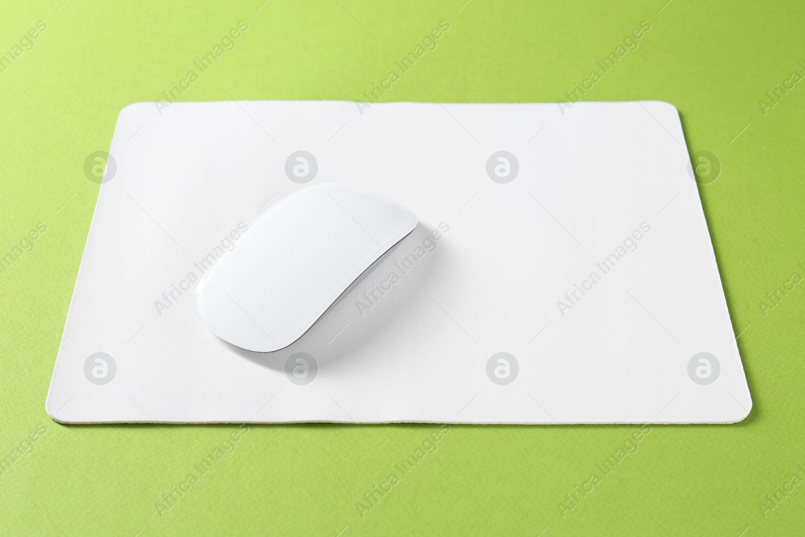 Photo of Wireless mouse and mousepad on green background