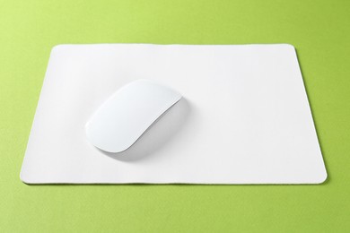 Photo of Wireless mouse and mousepad on green background