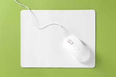 Photo of Wired mouse and mousepad on green background, top view