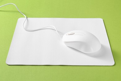 Photo of Wired mouse and mousepad on green background