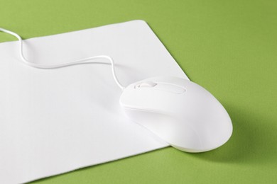 Photo of Wired mouse and mousepad on green background