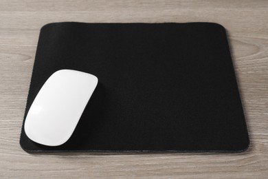 Wireless mouse and mousepad on wooden table