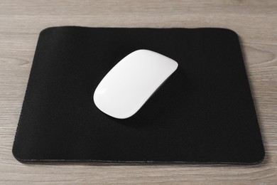 Photo of Wireless mouse and mousepad on wooden table