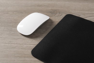 Wireless mouse and mousepad on wooden table