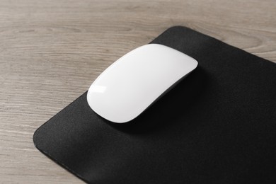 Wireless mouse and mousepad on wooden table