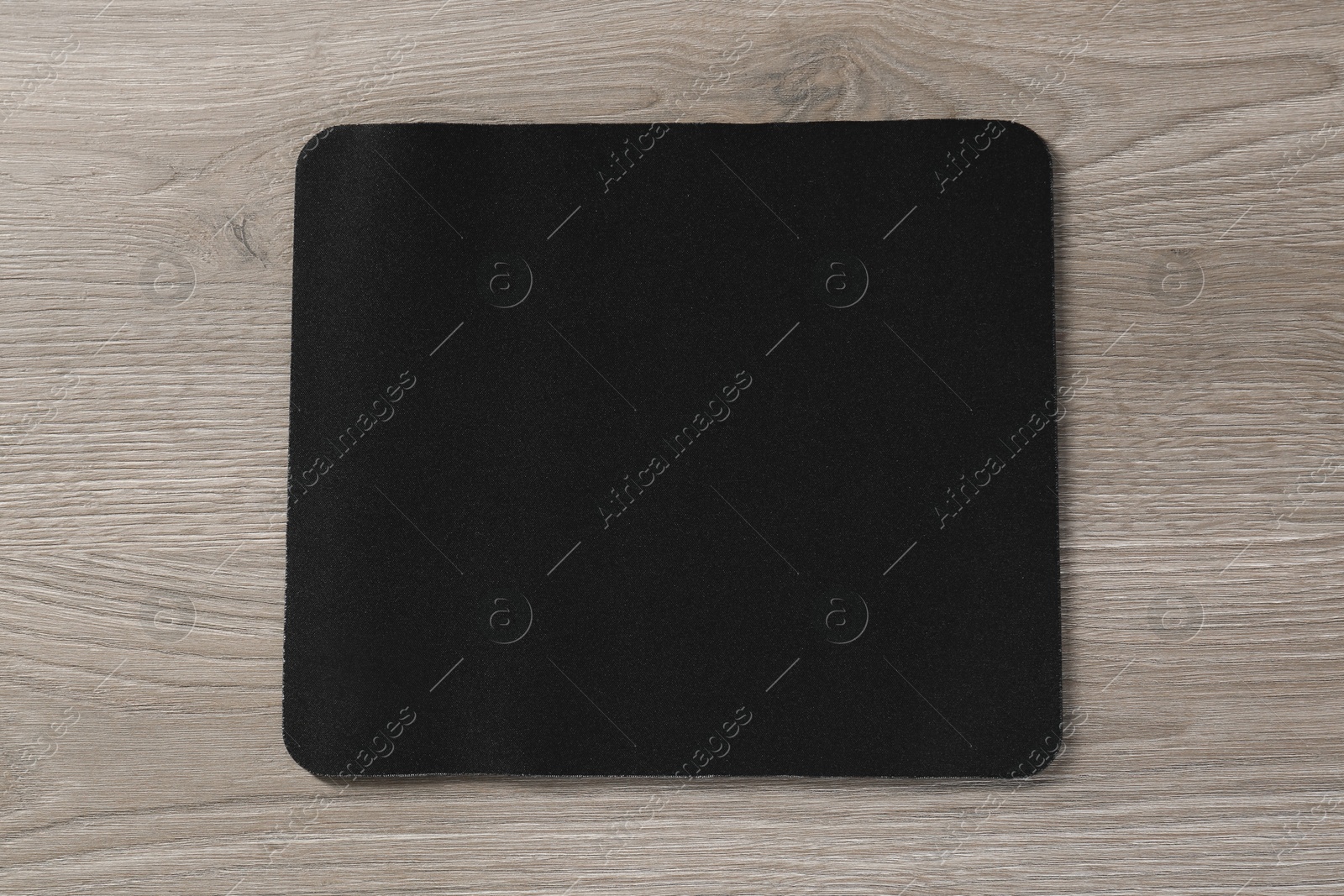 Photo of One black mouse pad on wooden table, top view