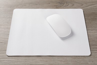 Wireless mouse and mousepad on wooden table