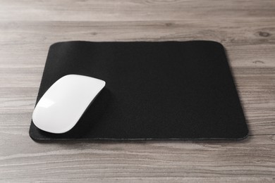 Wireless mouse and mousepad on wooden table