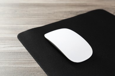 Wireless mouse and mousepad on wooden table