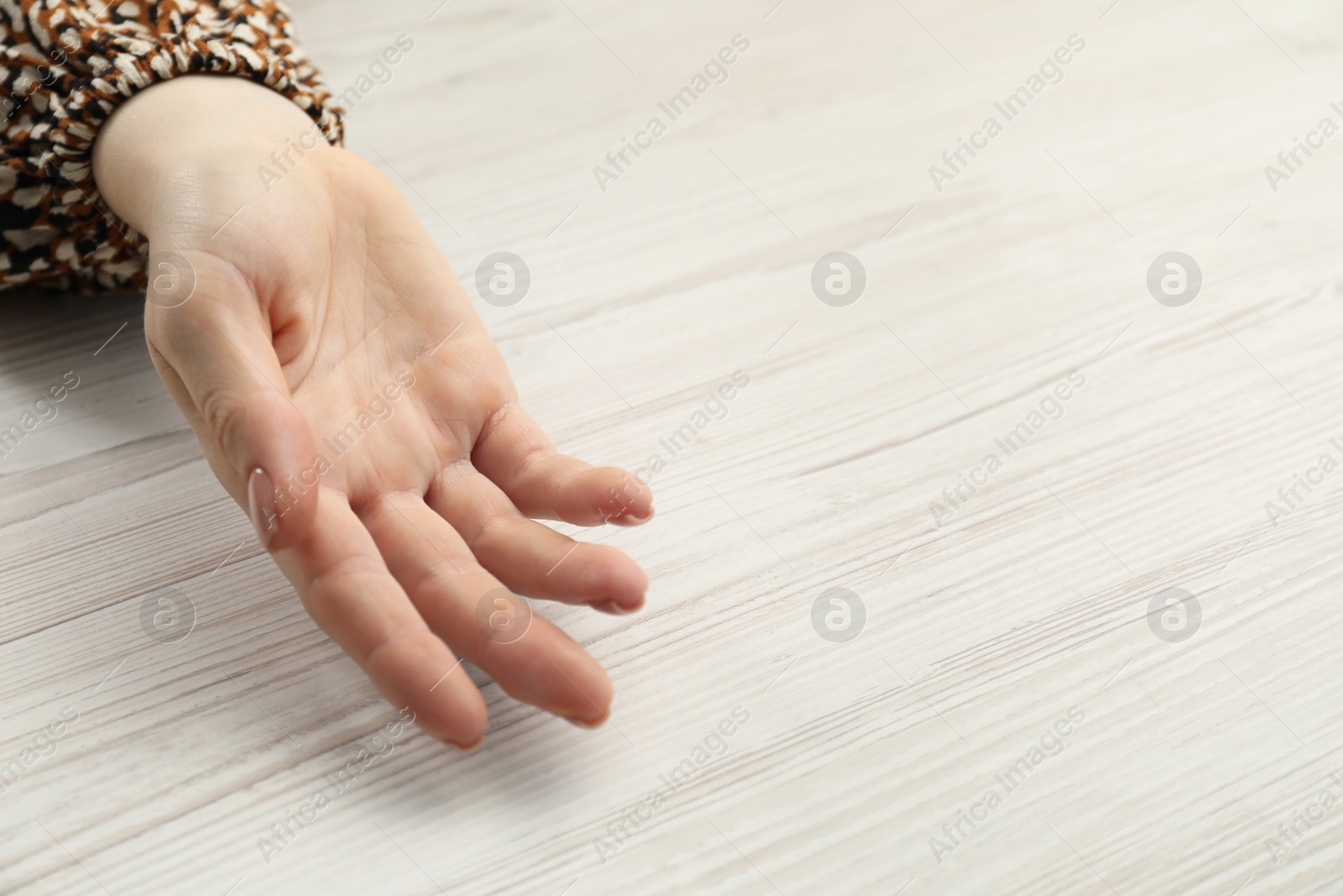 Photo of Chiromancy and foretelling. Woman showing palm at white wooden table, top view. Space for text