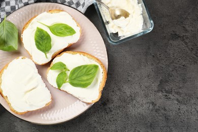 Delicious sandwiches with cream cheese and basil leaves on grey table, flat lay. Space for text