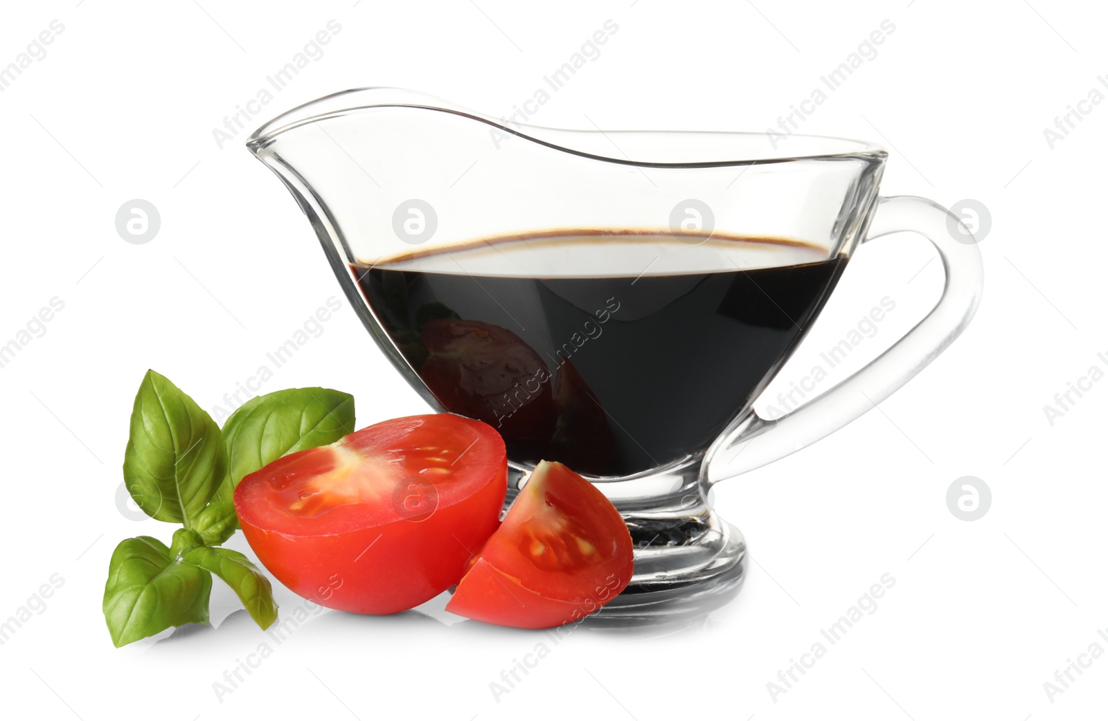 Photo of Balsamic vinegar in gravy boat, tomatoes and basil isolated on white