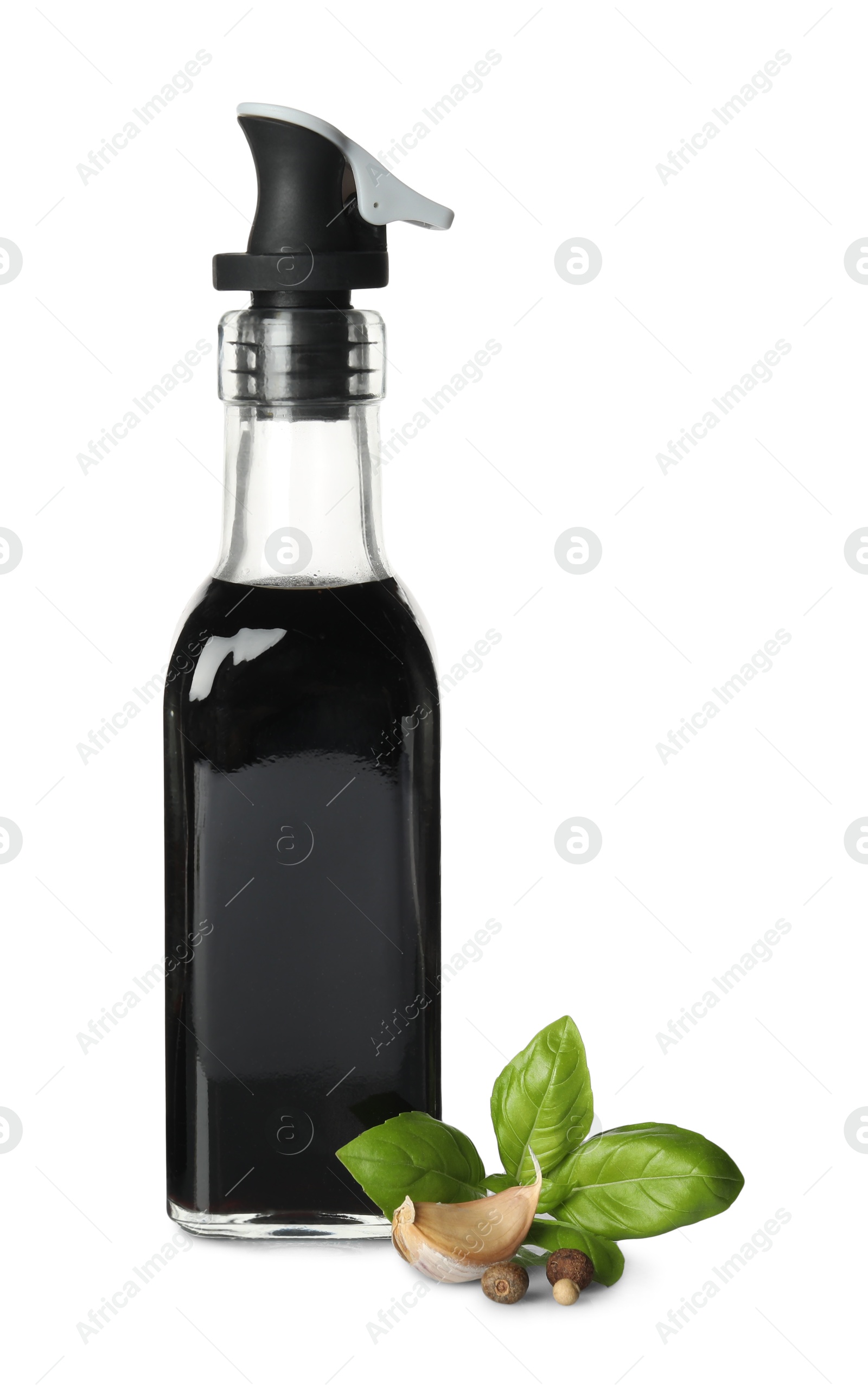 Photo of Balsamic vinegar in bottle, basil and spices isolated on white