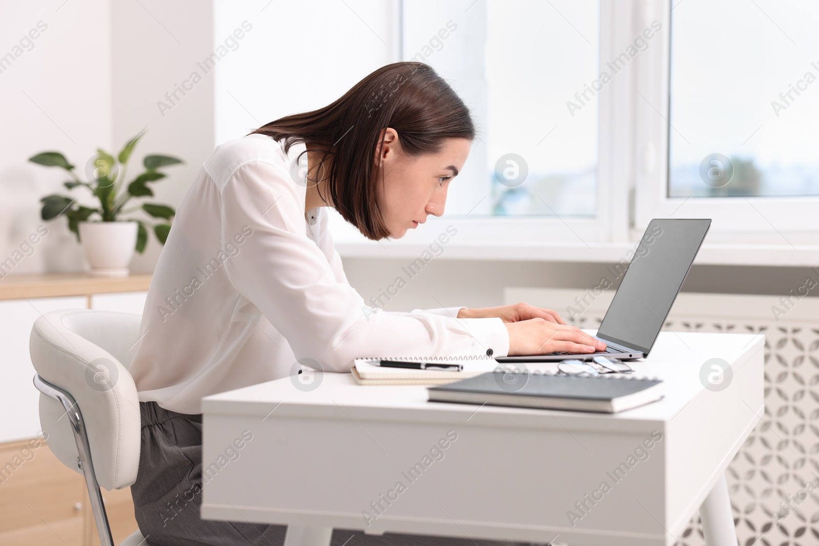 Photo of Woman with poor posture working in office