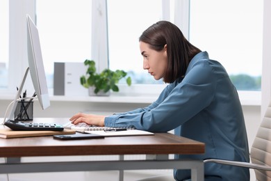 Photo of Woman with poor posture working in office