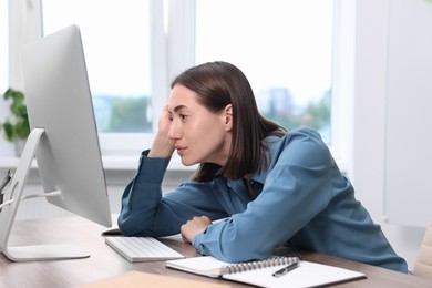 Woman with poor posture working in office