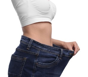 Photo of Diet and weight loss concept. Woman in big jeans showing her slim body on white background, closeup