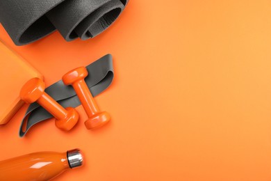 Photo of Dumbbells, yoga block, mat, thermo bottle and fitness elastic band on orange background, flat lay. Space for text