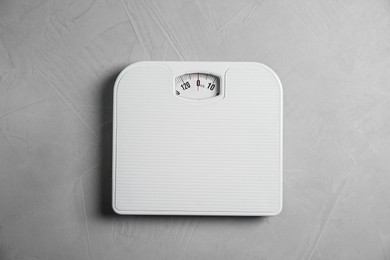 Photo of One bathroom scale on grey textured background, top view