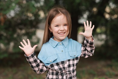Photo of Portrait of happy little girl outdoors. Cute child
