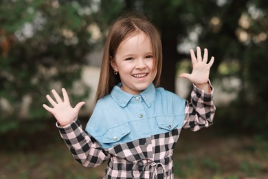 Portrait of happy little girl outdoors. Cute child