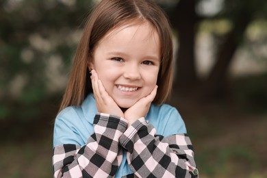 Photo of Portrait of happy little girl outdoors. Cute child