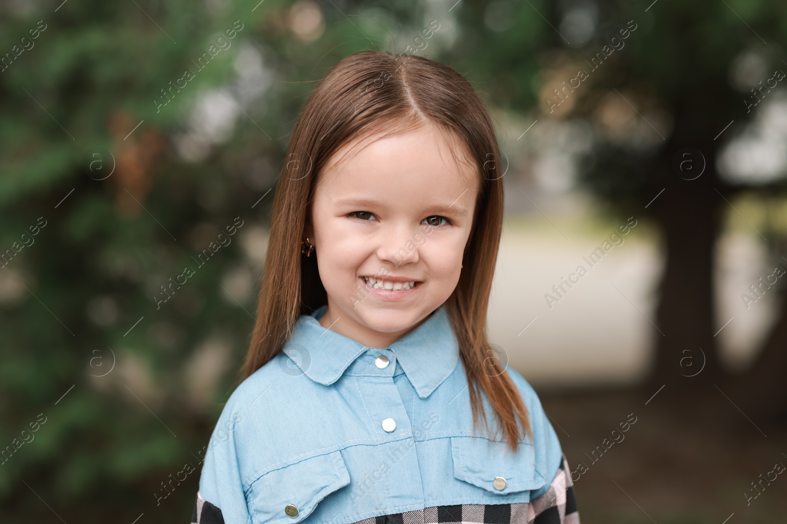 Photo of Portrait of happy little girl outdoors. Cute child