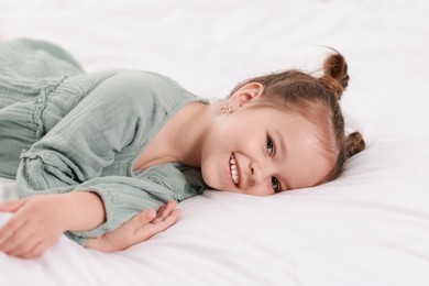 Photo of Portrait of happy little girl on bed