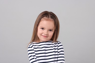 Portrait of cute little girl on grey background