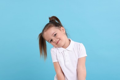 Photo of Portrait of cute little girl on light blue background